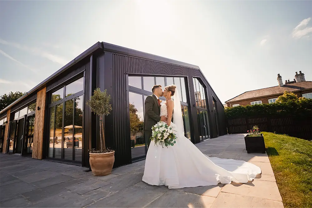 Kissing wedding couple barn